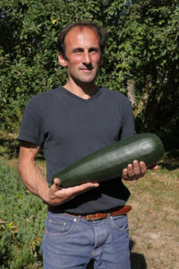 Alexandre Eymery et une courgette géante, ni amère, ni fibreuse malgré la taille ! Les bienfaits de l'agroécologie.